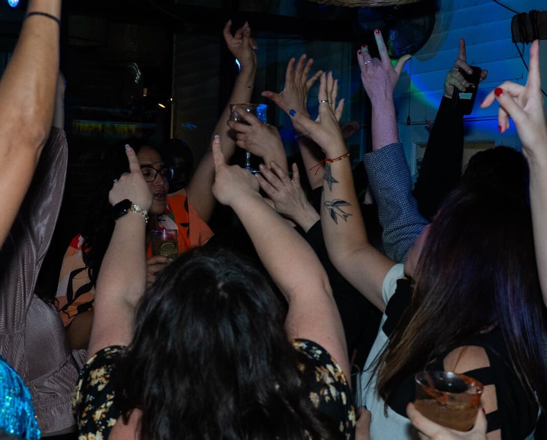 Guests dancing with hands raised during a DJ Gruvy nightlife set